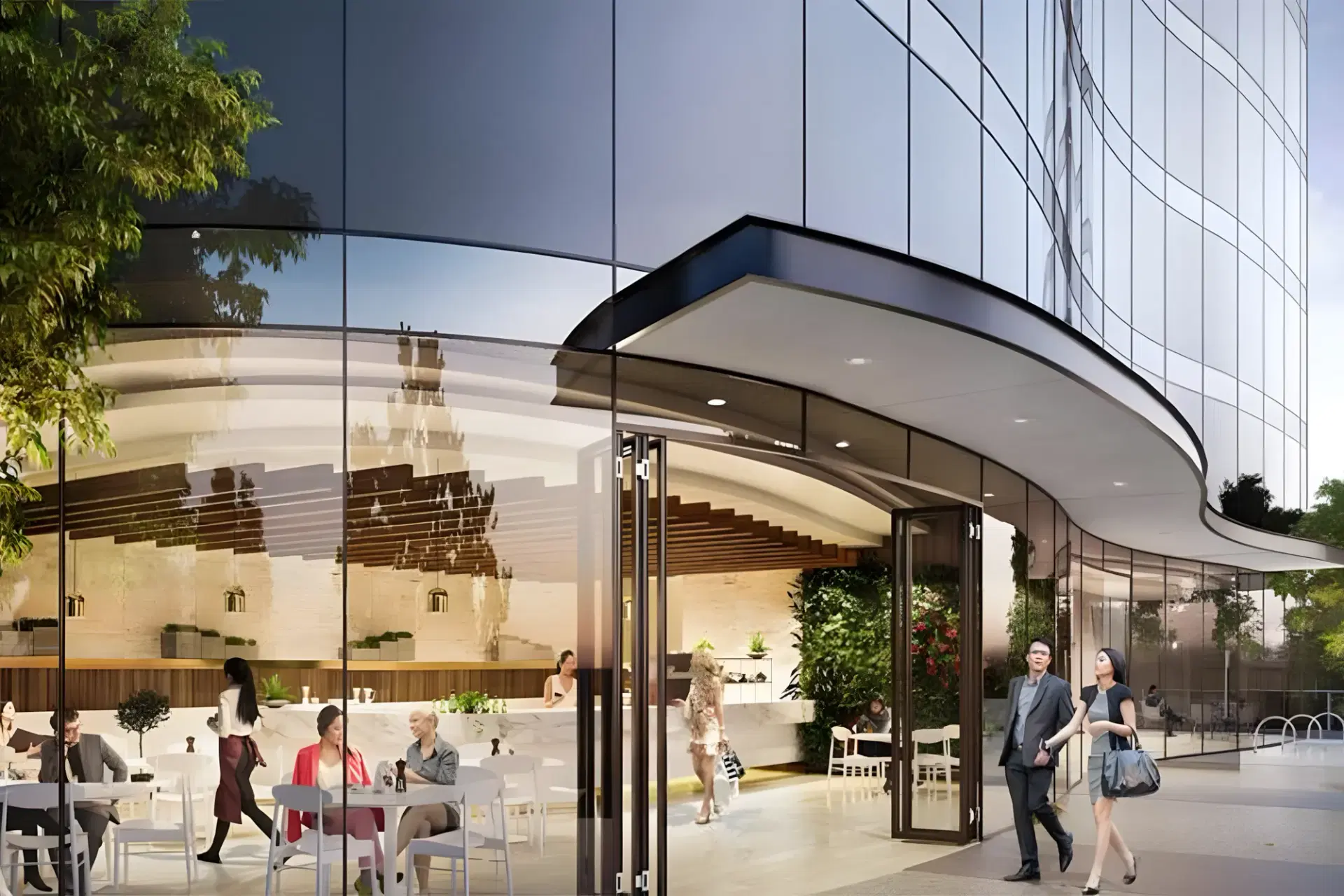 Curved glass facade and ground-floor cafe of the Box Hill apartment building at dusk